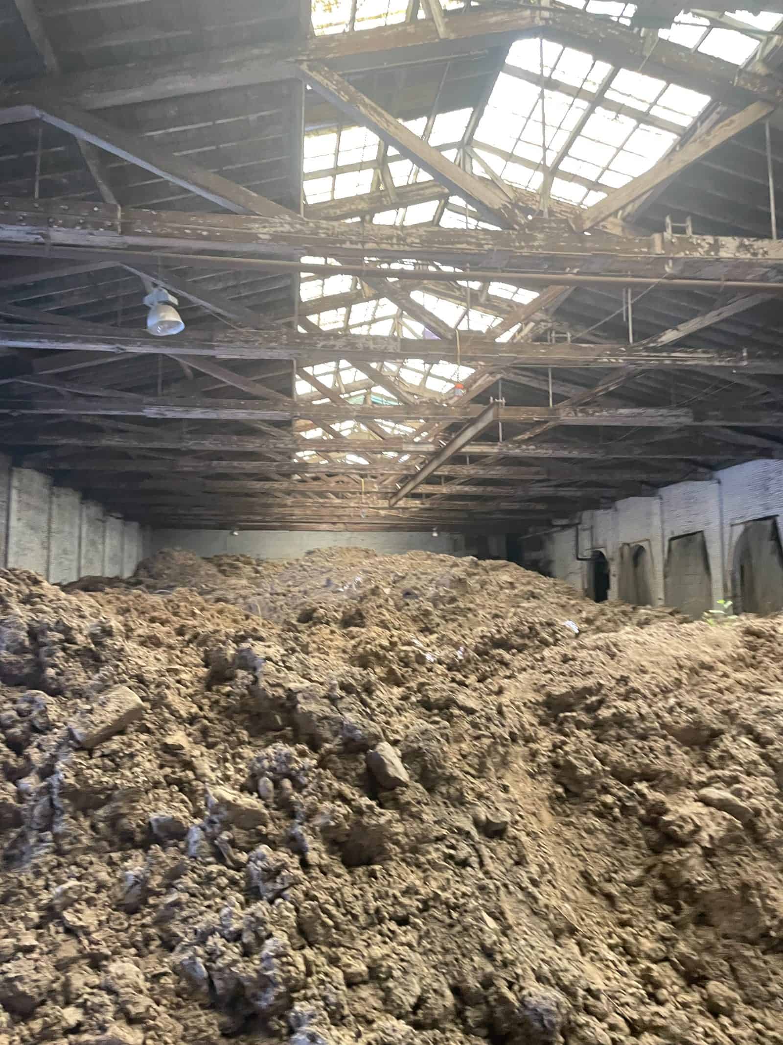 Excavated soil stockpiled inside a former industrial building during site remediation